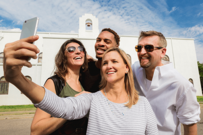 Group of people taking a selfie picture on a iphone.